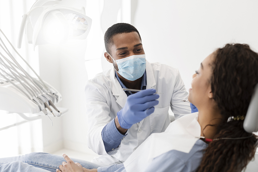 African american male dentist making treatment in modern clinic